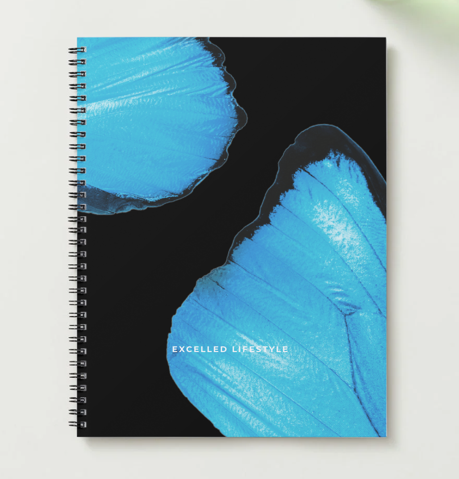 Spiral-bound planner with blue butterfly wings design on a black background, featuring the brand name.